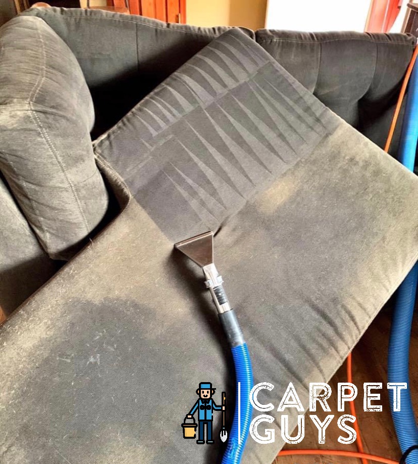 Upholstery extraction tool on fabric sofa — cleaning pass lines visible